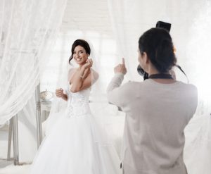 woman being photographed in wedding dress