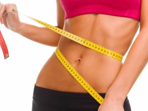 fit woman with a tape measure around her waist