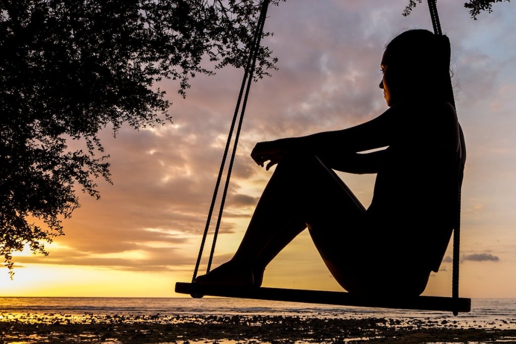 Silhouette of Woman on Swing during Golden Hour