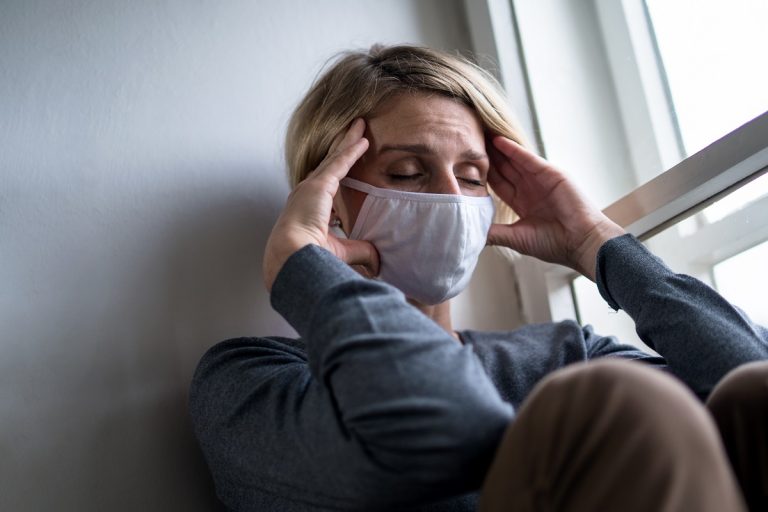 stressed woman wearing mask at home