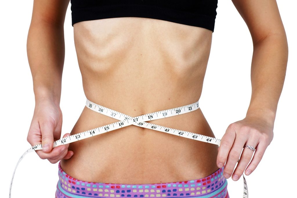 woman measuring her very thin waist