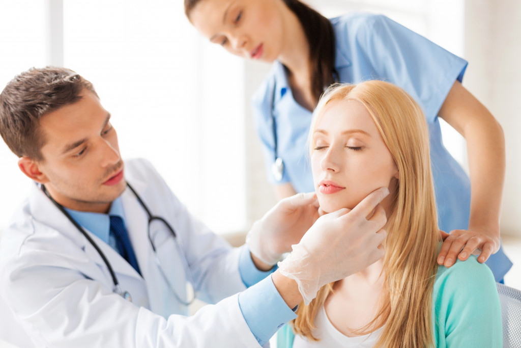 a dermatoogist examining womans face